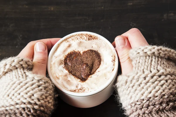 Ręce trzymając Cappuccino kształt serca — Zdjęcie stockowe