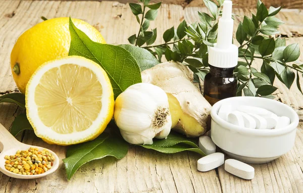 Alternatieve geneeskunde met knoflook, gember en citroenolie — Stockfoto