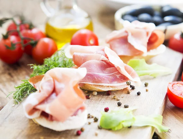 Prosciutto Ham Aperitiv cu condimente pe o placă de tăiere din lemn — Fotografie, imagine de stoc
