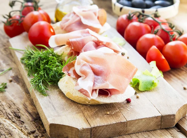 Prosciutto sonka előétel-egy fa vágódeszka, a fűszerek — Stock Fotó