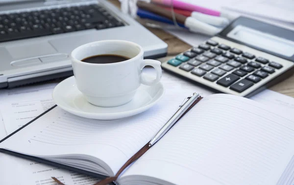 Taza de café en la oficina con documentos financieros, agenda y calculadora —  Fotos de Stock