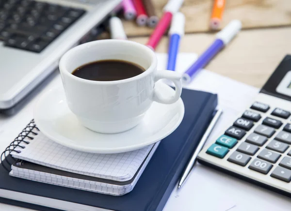 Tazza di caffè in ufficio con documenti finanziari, agenda e calcolatrice — Foto Stock