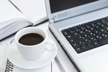 Ofisinde finansal kağıtları, bilgisayar ve Agenda.C kahve fincanı