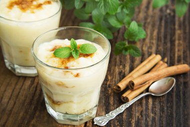 Rice Pudding with Cinnamon Powder and Mint Leaf in Cups clipart
