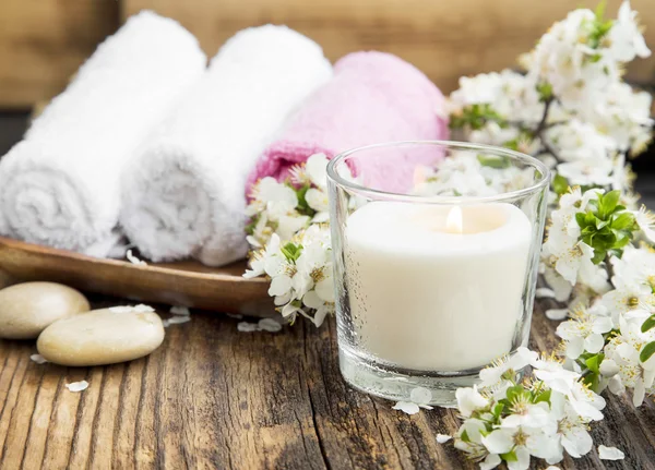Duftkerze mit weißen Blumen und Handtüchern für den Wellnessbereich — Stockfoto