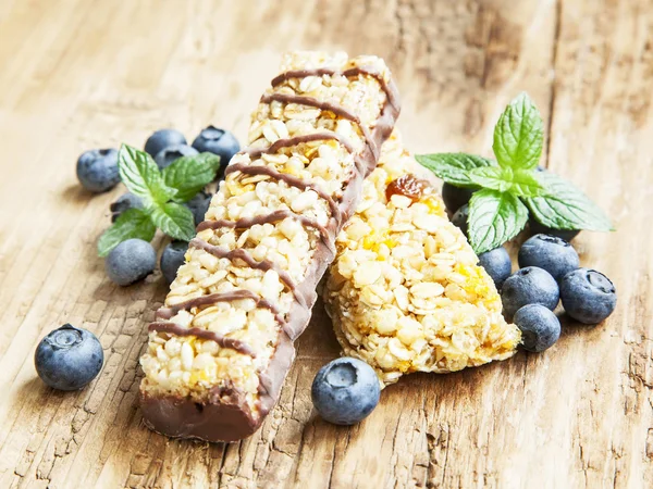 Barre de muesli au chocolat aux bleuets sur fond en bois — Photo