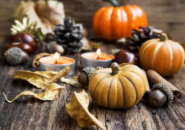 Herbstdekoration. Kürbisse, orangefarbene Kerzen, Zimt, Kastanien und — Stockfoto