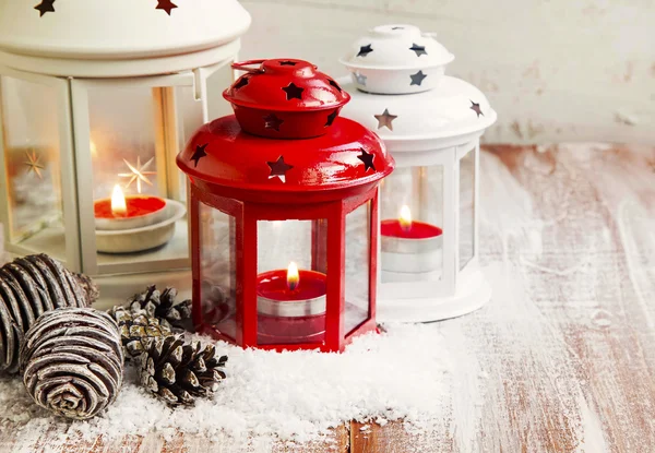 Винтажные рождественские фонари с красными и белыми свечами и снегом — стоковое фото