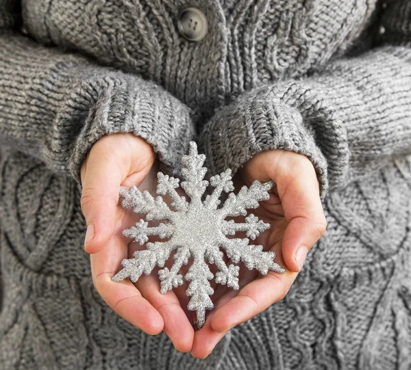 雪の結晶のクリスマスの装飾を保持している女性 — ストック写真