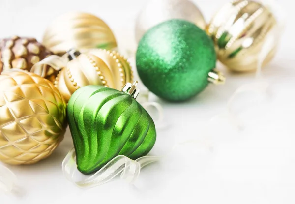 Grönt och gyllene juldekorationer med pärlskimrande glober och mudd — Stockfoto