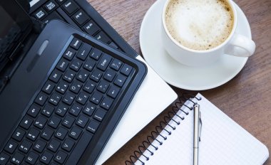 Laptop, kahve fincanı ve bir defter ile Office nesneleri