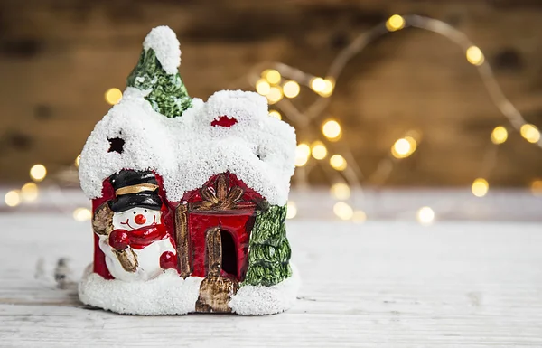 Праздничное украшение рождественского дома с маленьким снеговиком и рюкзаком — стоковое фото