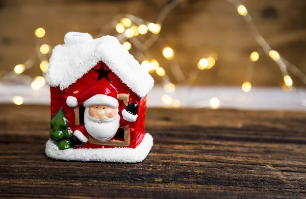 Christmas house decoration with Santa and festive lights on wood — Stock Photo, Image