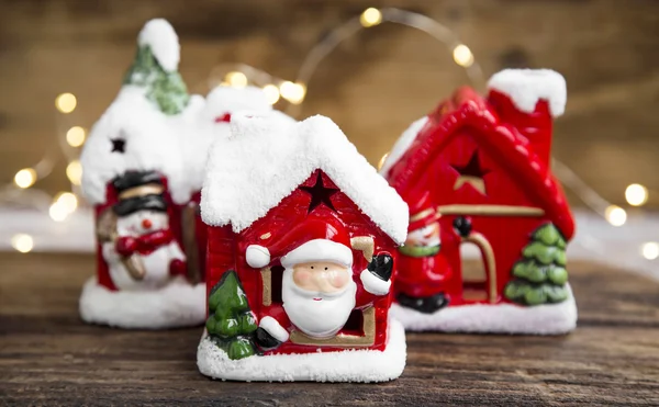 Декорации рождественских домов с праздничными огнями на деревянной доске — стоковое фото