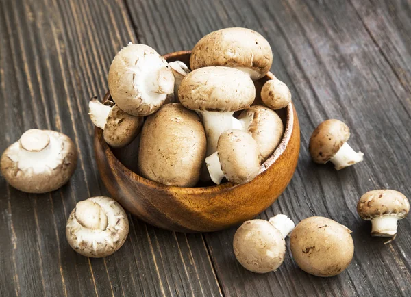 Bruin champignon paddestoelen in houten kom — Stockfoto