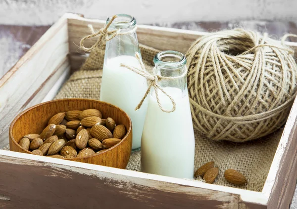 Almond milk in bottles with almond nuts bowl — Stock Photo, Image