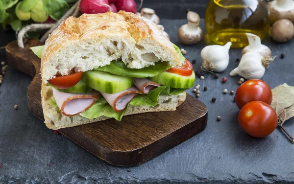 Сэндвич с ветчиной, свежим хлебом, салатом, помидорами и огурцом — стоковое фото