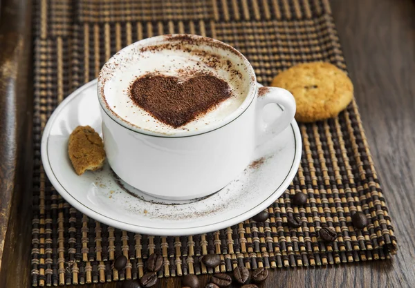 Cappuccino kopi latte dengan coklat berbentuk hati dan kue — Stok Foto