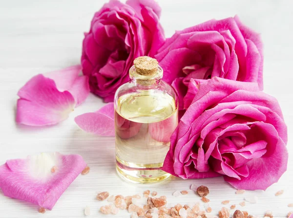 Rose water in a bottle with roses flowers and petals — Stock Photo, Image