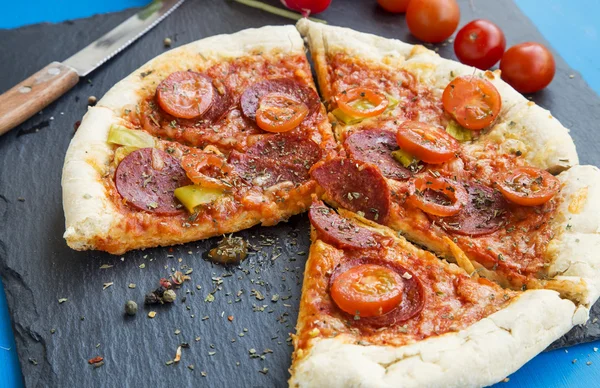 Pizza com carne de salame, tomates cereja e especiarias de orégano — Fotografia de Stock