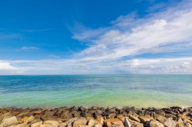 Deniz dalgaları ve muhteşem kayalık sahil manzarası, tropik deniz manzaralı ufuk. Dalga kırıcı kayalar, güneş ışığıyla kayalar. 