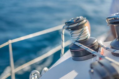 Mavi denizde yelken açan yelkenli. Turizm, güneşli bir günde denizde yelken açarken yelkenli teçhizatı ayrıntıları.