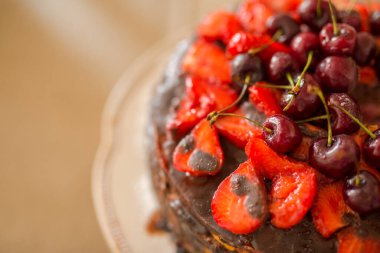 Yakın plan çikolatalı çilekli pasta ve üstünde biraz kiraz. Tatlı, lezzetli bir pasta fotoğrafı.