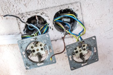 Duvardaki klima prizini aç. Görülen kablolarla evdeki elektrik prizi tamiri. Yeni elektrik prizleri patlak. Elektrik kabloları, elektrik kabloları, eski bir beton bina duvarındaki soket, ev onarımı.
