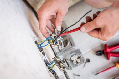 Tornavidayla elektrikli ellerin kapatılması soket onarımı, yenileme, elektrik ve insan konsepti.