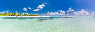 Panoramic view of exotic palm trees and lagoon on the tropical Island beach. Boats in shallow tropical sea lagoon. Amazing panorama in Maldives. Idyllic beach weather, summer vibes, relaxing vacation, carefree holiday mood. clipart
