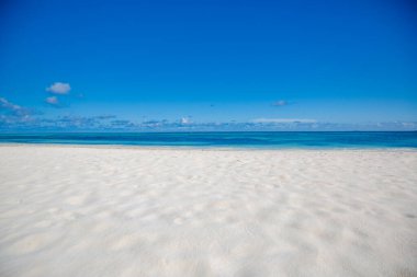 Sonsuz plaj sahnesi, sakin yaz manzarası. Mavi gökyüzü ve yumuşak okyanus dalgaları. Yaz mevsimi deniz manzarası güzel dalgalar, güneşli bir günde mavi deniz suyu. Sığ deniz, inanılmaz tropikal doğa arka planı. Dalgalar ve kumsal kumlarıyla güzel, parlak bir deniz.