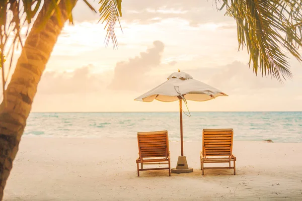 美丽的热带日落风景 两张日光浴床 棕榈树下的伞 白色的沙滩 地平线上的海景 色彩斑斓的暮色天空 宁静和悠闲 具有启发性的海滨度假酒店 — 图库照片