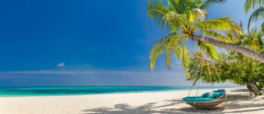 Plaj manzarası olarak tropik plaj manzarası. Plaj salıncakları ya da palmiye ağaçlarının üzerinde sallanan hamak. Plaj pankartı için sakin deniz. Mükemmel bir plaj manzarası tatili ve yaz tatili şablonu. Lüks plaj tatil köyü