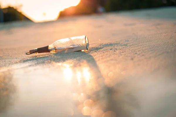 Bottle with a message. Idyllic getaway concept, bottle floats in the surf line. Lost in nature, tropical coast shore with soft sand and sunlight template