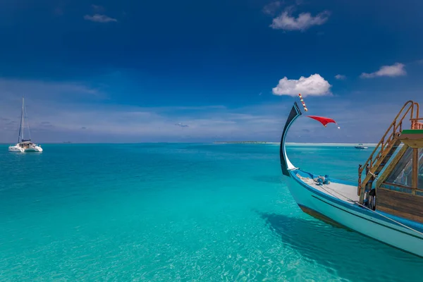 Inspirational Maldives beach design. Maldives traditional boat Dhoni and perfect blue sea with lagoon. Luxury tropical paradise concept, cruise, sailing in tropical paradise