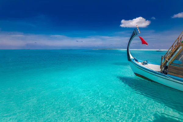 Inspirational Maldives beach design. Maldives traditional boat Dhoni and perfect blue sea with lagoon. Luxury tropical paradise concept, cruise, sailing in tropical paradise