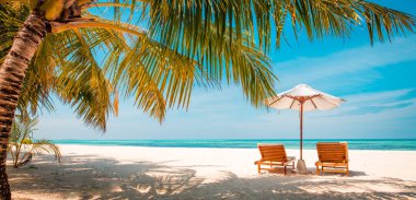 Beautiful beach. Chairs on the sandy beach near the sea. Summer holiday and vacation concept for tourism. Inspirational tropical landscape. Luxury travel background, sunny scenery with palm tree leaves and idyllic carefree relaxing mood, vibes