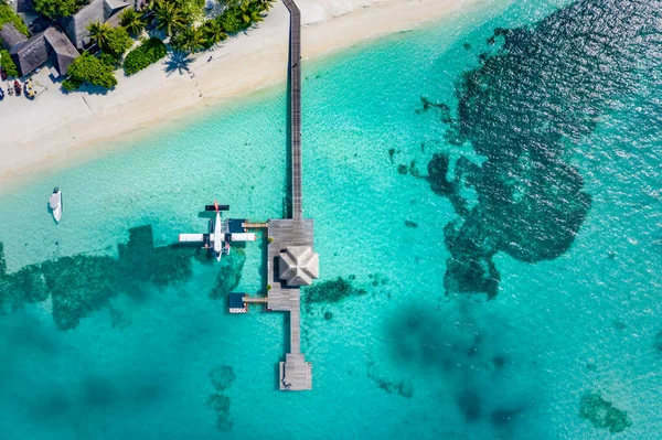 モルディブの熱帯の島に接近する水上飛行機の空中ビュー 素晴らしい空中風景 水上ヴィラ 桟橋と白い砂の上に見事なビーチの風景 豪華な夏の旅行と休暇の目的地 幻想的なドローンビュー — ストック写真