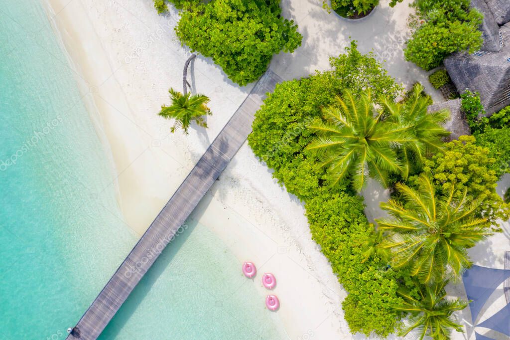 Aerial view of a island in the Maldives with turquoise waters. Luxury water villas bungalows. Panoramic aerial view of a tropical island in the Indian Ocean with turquoise waters and white sand beaches, Maldives