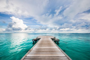 Ahşap iskele üzerinde dramatik renkli günbatımı dramatik gökyüzü. Ahşap iskele ya da iskele dramatik günbatımında deniz suyunda kalır ve gökyüzü suyu yansıtır.