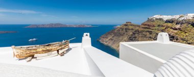 Oia ve Fira şehirleri, Yunanistan 'ın Santorini adası: Panoramik manzara, Caldera, Ege denizi üzerinde mavi kubbeleri olan geleneksel beyaz mimari ve ünlü beyaz evler ve kiliseler üzerinde güneşli gökyüzü. Lüks yaz tatili, romantik tatil.