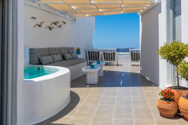 Mayıs 08.19 - Santorini, Yunanistan: Yunanistan 'ın Santorini adasında beyaz mimari ve mavi deniz. Yaz tatilleri, seyahat merkezleri konsepti. Deniz manzaralı jakuzi. Lüks otel terası.