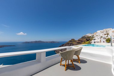 Santorini Adası, Yunanistan 'da beyaz mimari. Mavi deniz manzaralı, güneşli mavi gökyüzü olan Caldera 'da rahatla. Lüks yaz tatili, tatil. Çiftler için sandalyeler, romantizm, aşk, balayı yeri