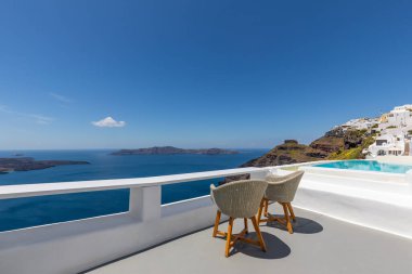 Santorini Adası, Yunanistan 'da beyaz mimari. Mavi deniz manzaralı, güneşli mavi gökyüzü olan Caldera 'da rahatla. Lüks yaz tatili, tatil. Çiftler için sandalyeler, romantizm, aşk, balayı yeri