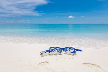 Şnorkel teçhizatlı yaz sahili manzarası, yumuşak kumda google 'lar ve su sıçratan sakin dalgalar. Tropik yaz sahili manzarası, tatil ya da tatil konsepti. Eğlence aktivitelerinin rahatlama görüntüsü, şnorkelle yüzme.