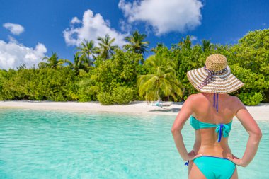 Tropikal plajda bikinili güzel bir kadın.