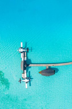 Ahşap tekne Dhoni ve tropikal plajla Maldivler 'in güzel hava manzaralı iskele deniz manzaralı harika mavi deniz üzerinde iskele. Lüks seyahat ve tatil konsepti. İnanılmaz bir hava manzarası.