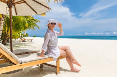Tropikal sahilde dinlenen güzel bir kadın.  