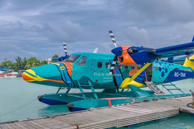 Erkek, Maldivler - 08.17.2019: Trans Maldivian Havayolları 'nın deniz uçağı limanda ve hava bulutlu. Deniz uçağında özel uçak boyası, Maldivler hava taşımacılığı