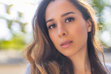 Kameraya bakan uzun saçlı güzel bir genç kadının portresini yakından çek.